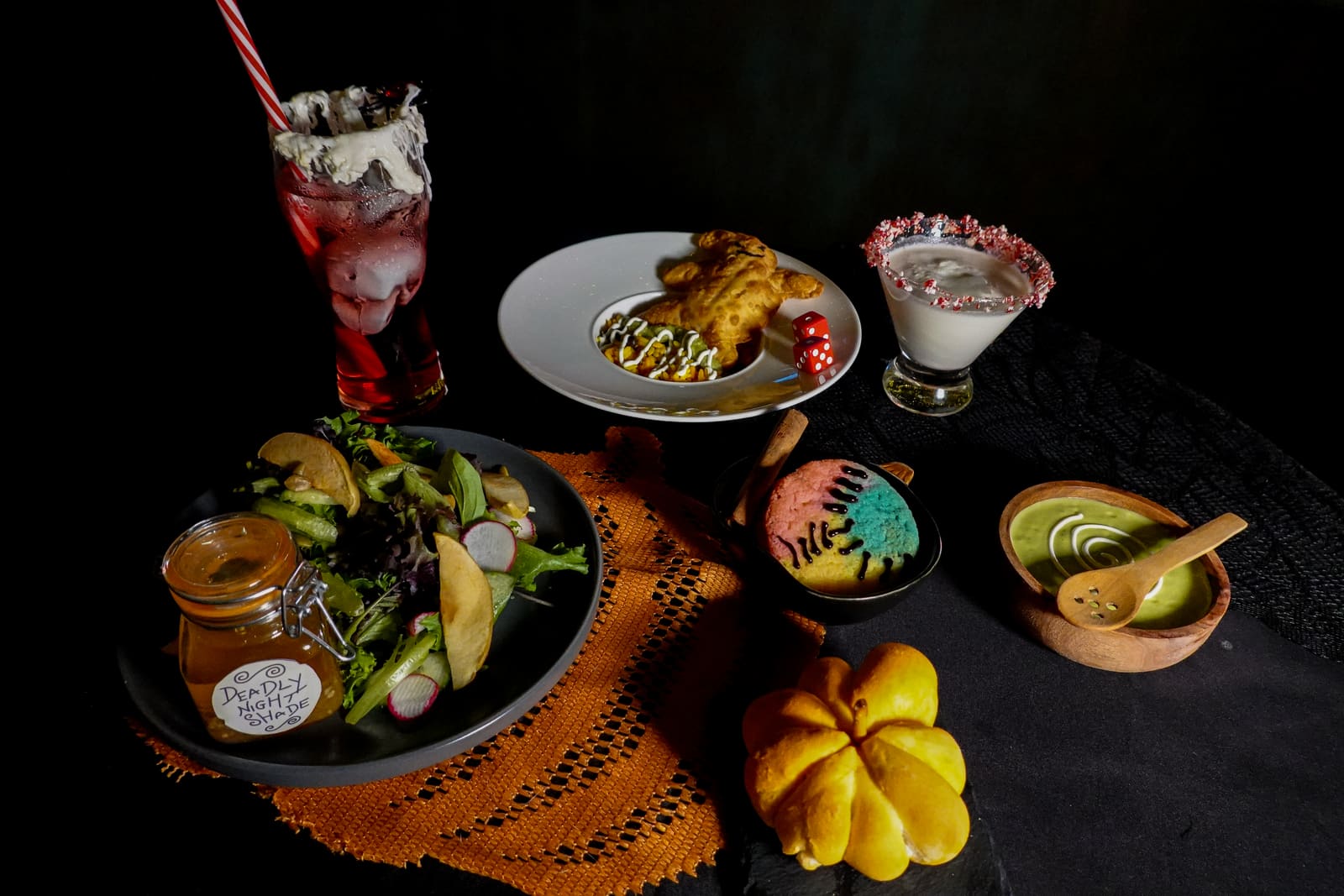 A full table spread of plated courses with two themed cocktails
