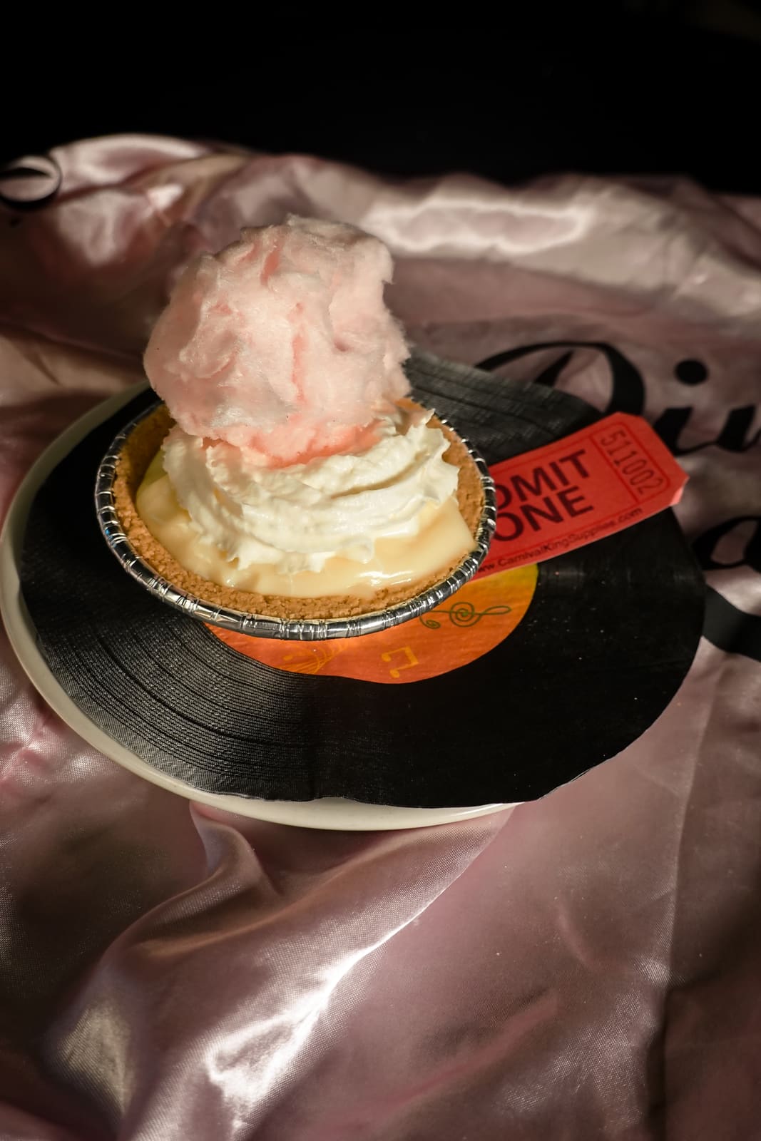 A frosted dessert served on a vinyl record on pink satin