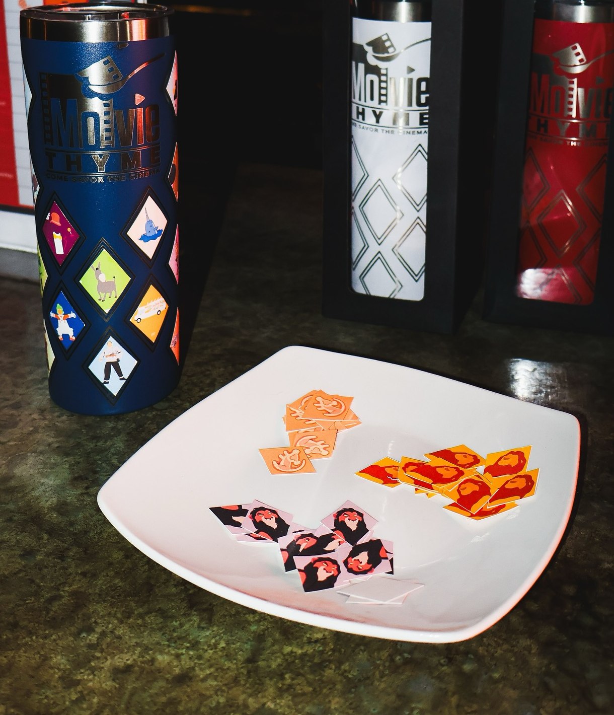 Movie Thyme branded tumblers and character stickers displayed on a counter